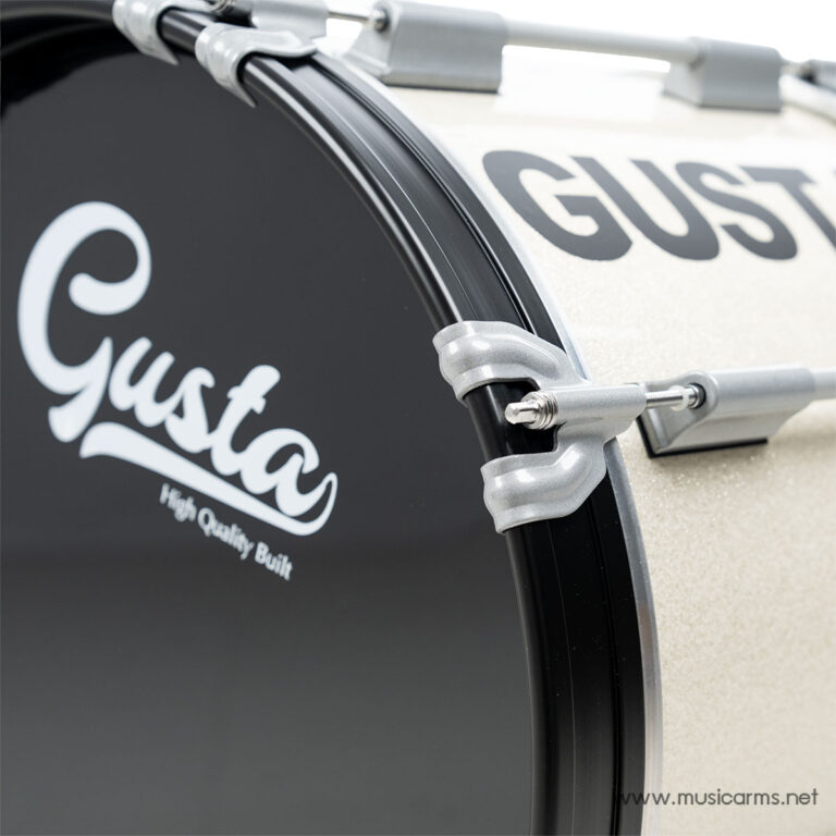Close-up of a Gusta bass drum head, showing tension rods and lugs securing the hoop on a beige glitter shell. ขายราคาพิเศษ