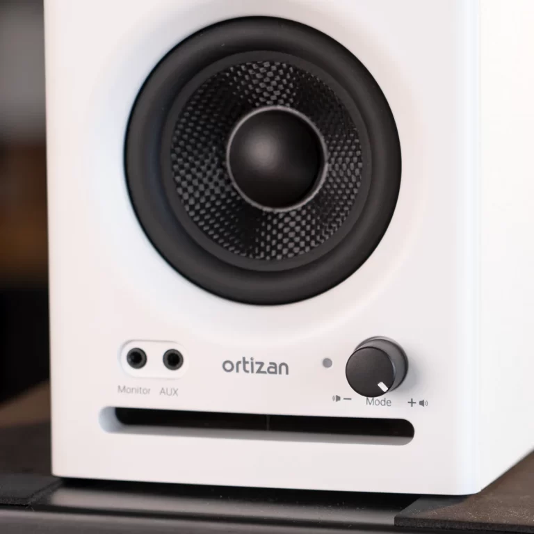 White Ortizan desktop speaker with a large black woofer, two input jacks (Monitor, AUX) and a Mode/volume knob on the front panel. ขายราคาพิเศษ