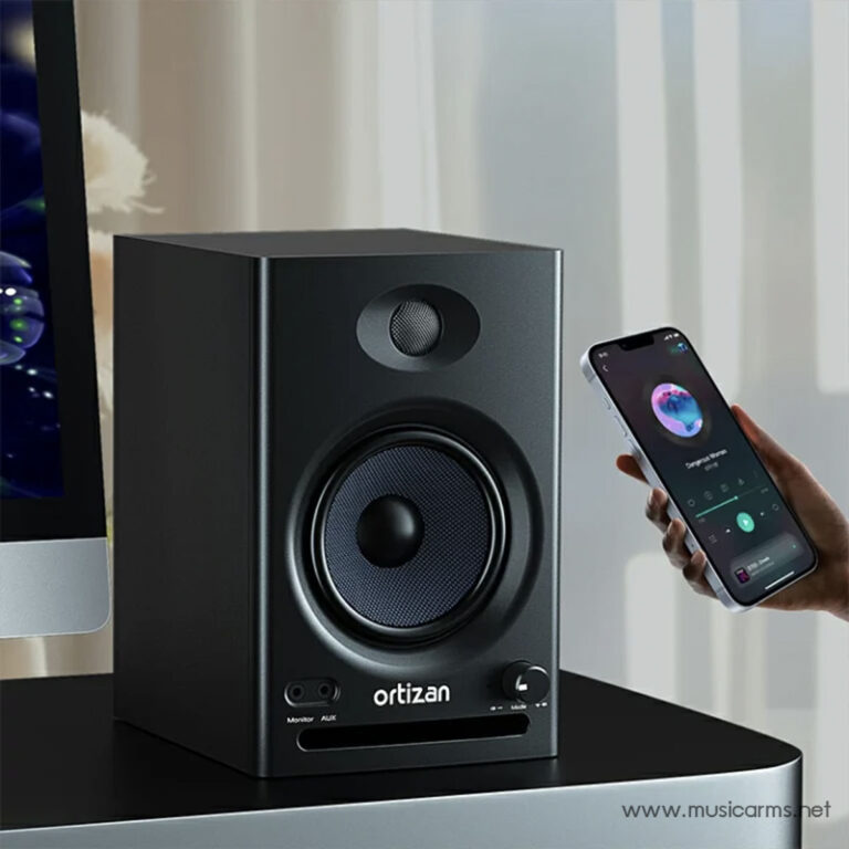 Black Ortizan desktop speaker on a table, with a smartphone nearby showing a music app (illustrates wireless audio playback). ขายราคาพิเศษ