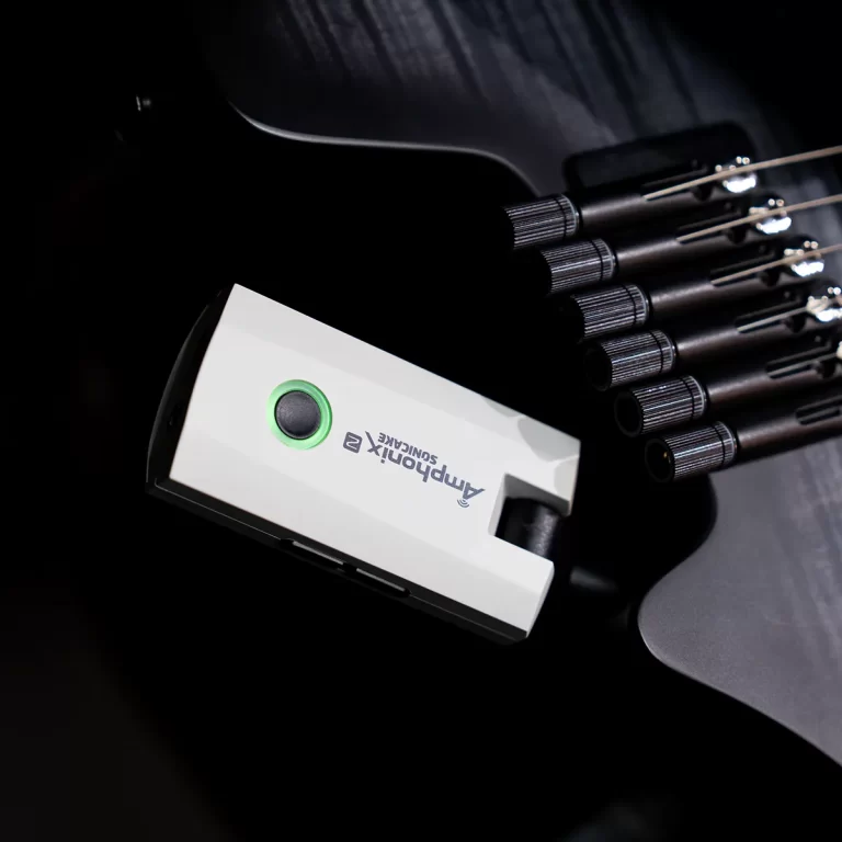 Close-up of a white external guitar pickup device mounted on a dark electric guitar, featuring a green power button. ขายราคาพิเศษ
