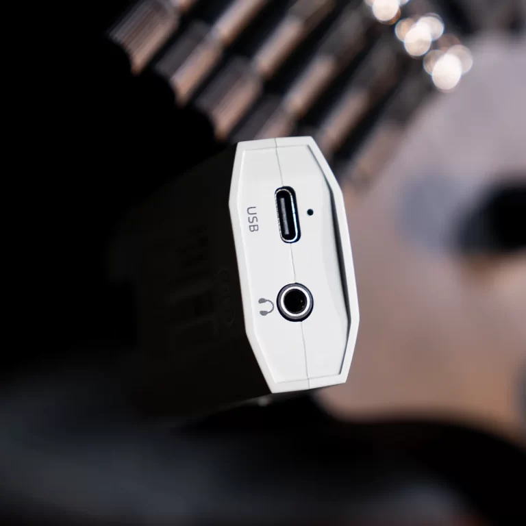 Close-up of a white USB-C adapter end showing a USB-C port and a 3.5mm audio jack in a dark scene. ขายราคาพิเศษ