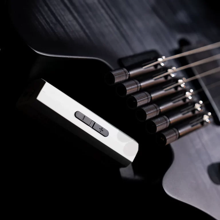 Close-up of a black electric guitar body featuring a white tremolo bridge and six strings sweeping toward the neck. ขายราคาพิเศษ