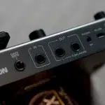 Close-up of an audio interface panel showing IN and OUT jacks, with L and R (balanced) outputs and a mic input nearby ขายราคาพิเศษ