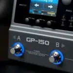 Close-up of a GP-150 guitar effects unit with two blue-ringed knobs labeled A and B and the words 'TUNER' and 'HOLD FOR LOOPER' visible beneath, showing its front panel detail. ขายราคาพิเศษ