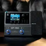 Valeton GP-150 multi-effects pedal with a colored display showing 'Tweedy OD' and two blue-topped knobs in foreground. ลดราคาพิเศษ