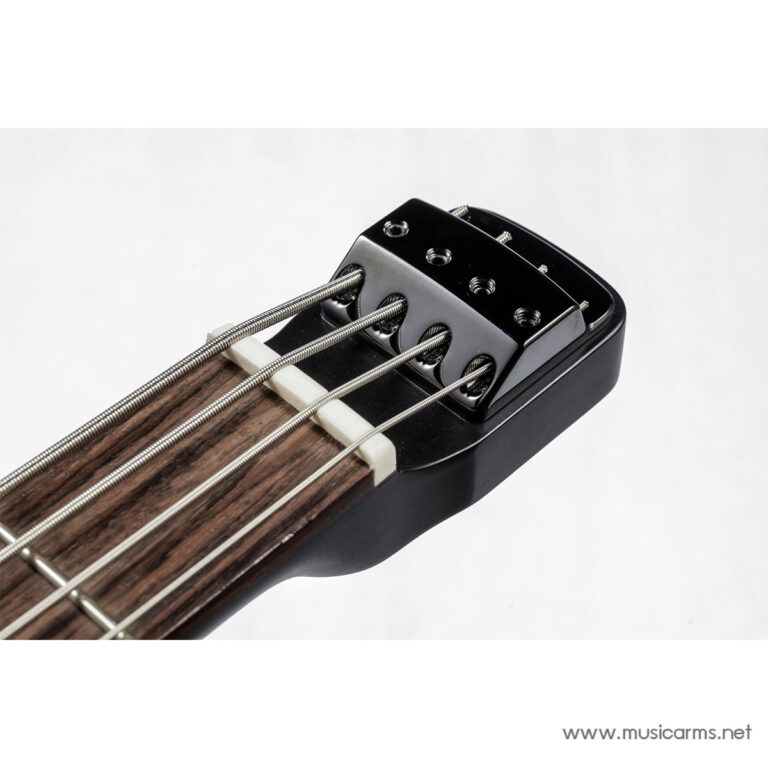 Close-up of a bass guitar bridge with four metal strings running over a wooden neck. ขายราคาพิเศษ