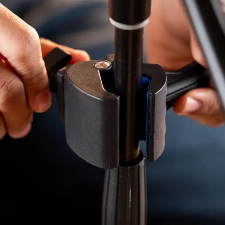 Hands tighten a clamp around a vertical stand pole, securing the height adjustment brakes for a tripod/mloor stand. ขายราคาพิเศษ