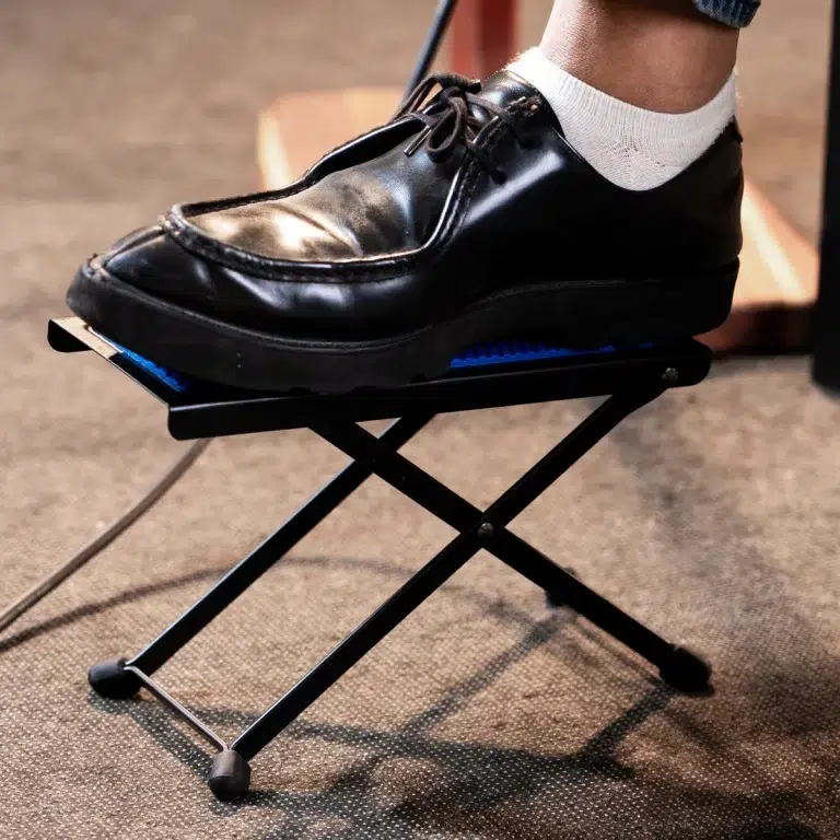 Person wearing a white sock presses a blue-backed pedal on a small portable exercise machine with a black frame. ขายราคาพิเศษ