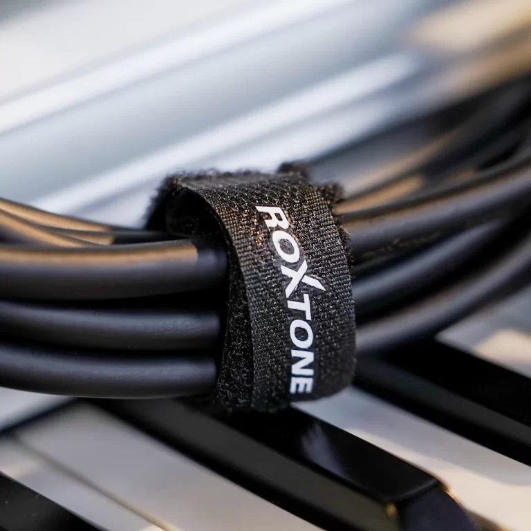 Close-up of a black Velcro strap around bundled cables, labeled ROXTONE/ROXTONE branding visible on the strap ขายราคาพิเศษ