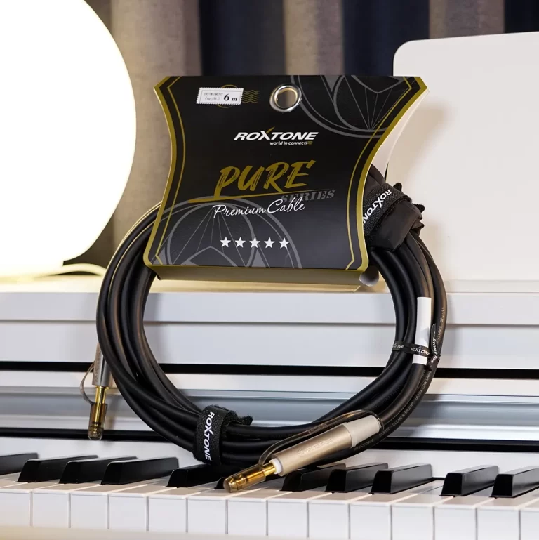 ROXTONE Pure Premium Cable packaging with two coiled black cables on a white piano surface. ขายราคาพิเศษ