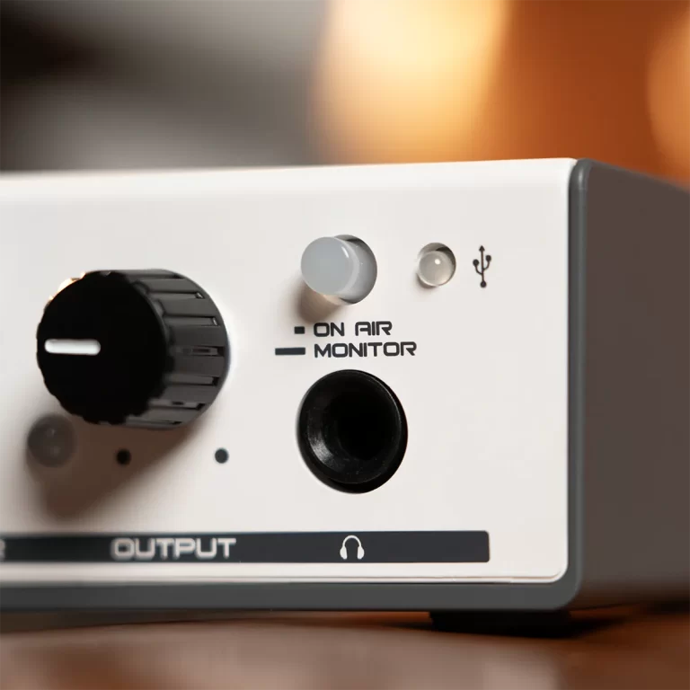 Close-up of an audio interface front panel showing ON AIR and MONITOR indicators, a large black knob, a small gray knob, and a headphone/output label on white housing. ขายราคาพิเศษ