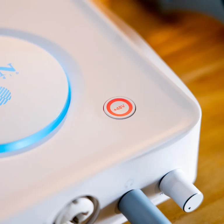 Power button on a white electronic device with a red ring, labeled 48V, with blue illuminated ring and connected cables nearby ขายราคาพิเศษ