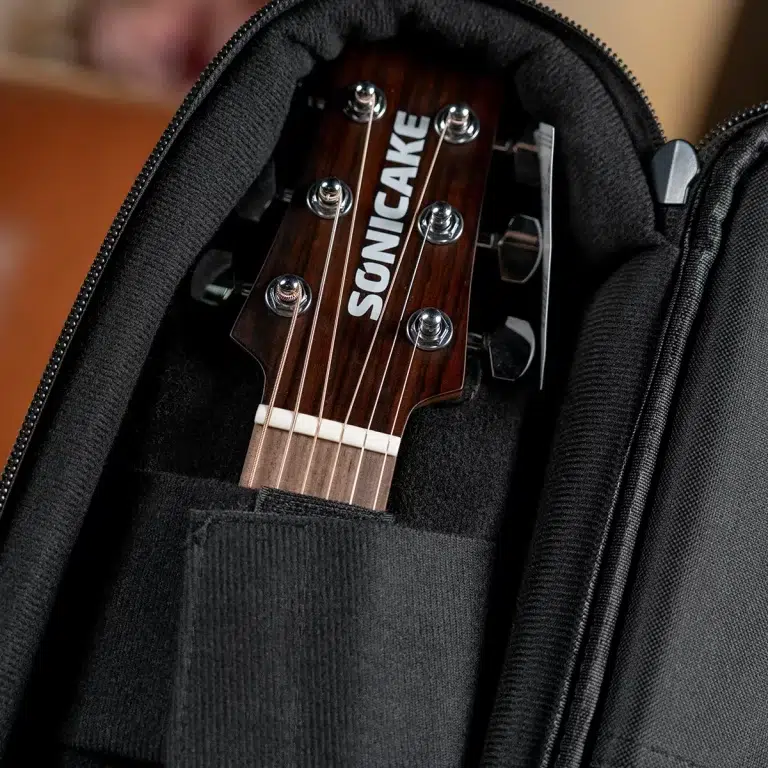 Close-up of a SONICAKE guitar headstock inside a padded black case. ขายราคาพิเศษ