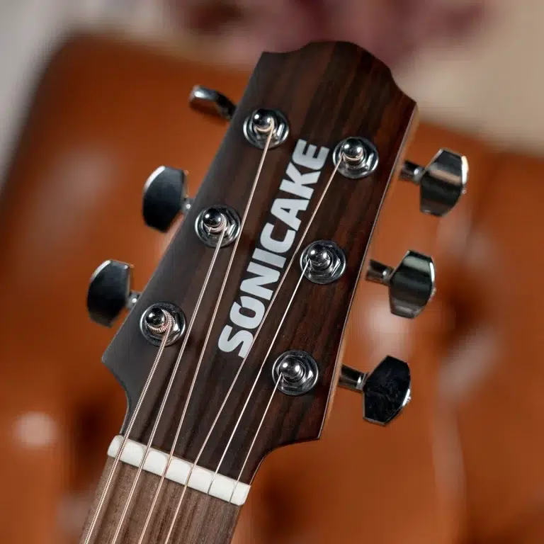 Close-up of a dark wooden guitar headstock with six chrome tuners and strings, featuring the 'SONICAKE' logo. ขายราคาพิเศษ