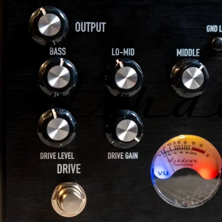Close-up of guitar amplifier panel with knobs for Bass, Lo-Mid, Middle, Drive Level, and Drive Gain, plus a VU meter on the right side ขายราคาพิเศษ
