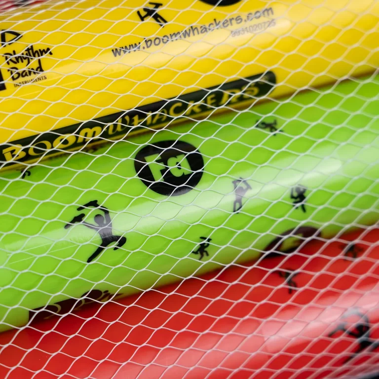 Colorful stack of Boomwhackers tubes (yellow, green, red) seen through a white safety net. ขายราคาพิเศษ