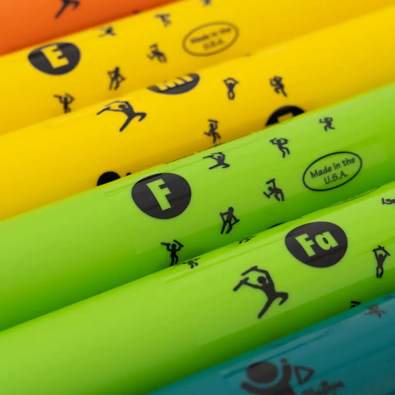 Close-up of neon-colored markers stacked diagonally with small black icons and circular labels such as 'Made in the U.S.A.' ขายราคาพิเศษ