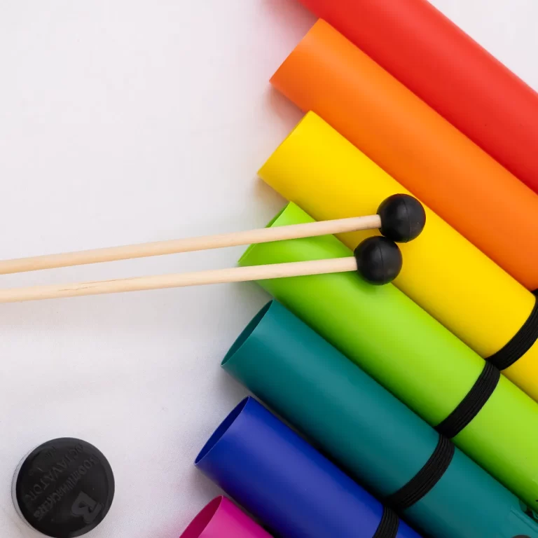Rainbow row of rolled foam mats diagonally with two wooden drumsticks crossing them. ขายราคาพิเศษ