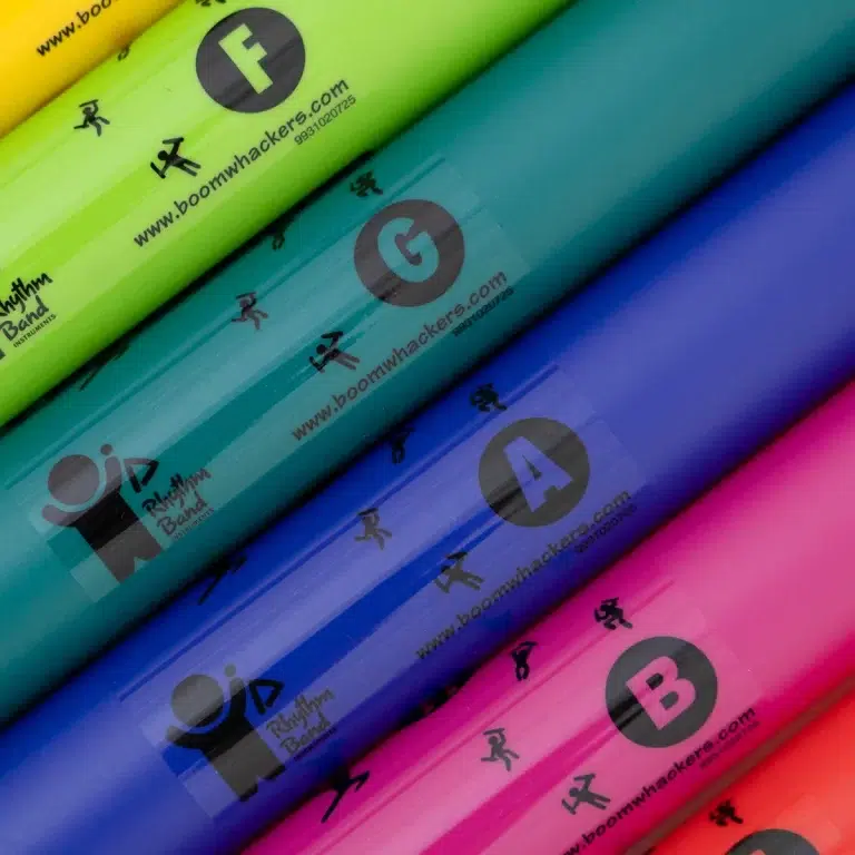 Colorful stacked Boomwhackers tubes in yellow, green, teal, blue, and pink with logos and small figures on each tube ขายราคาพิเศษ
