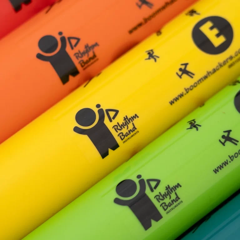 Rows of neon orange, yellow, and green markers featuring the Rhythm Band Instruments logo and branding. ขายราคาพิเศษ