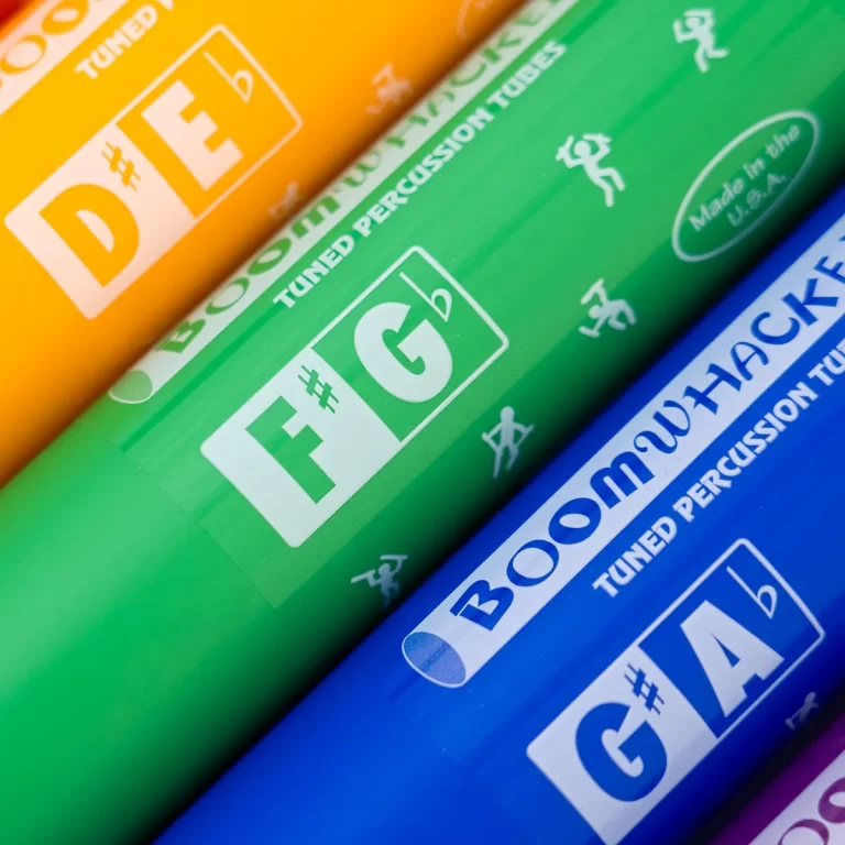 Colorful Boomwhackers tuned percussion tubes in orange, green, and blue with white labels showing (notes) and 'tuned percussion tubes' text visible on the labels. ขายราคาพิเศษ