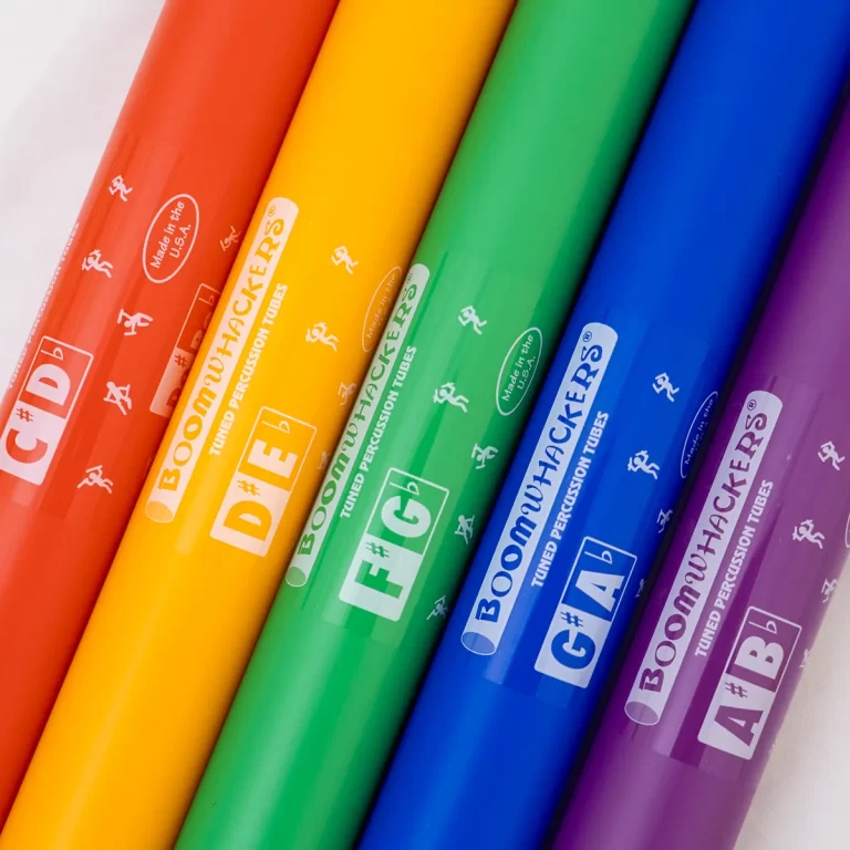 Row of bright Boomwhackers percussion tubes arranged diagonally in rainbow colors on a light background. ขายราคาพิเศษ