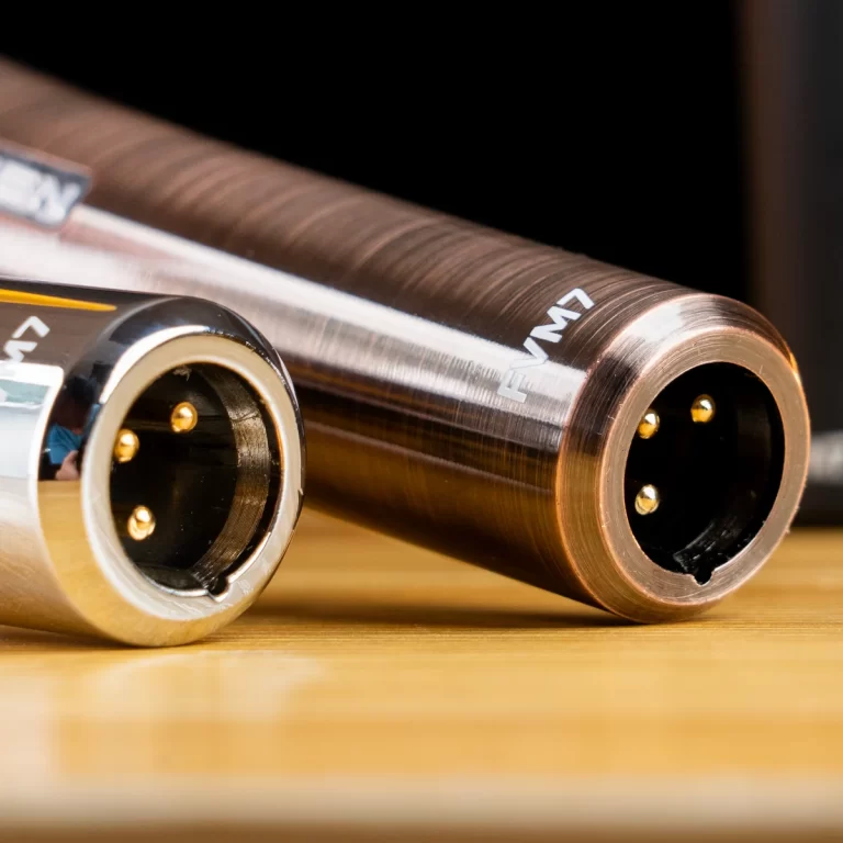 Close-up of two metal round multi-pin connectors with gold pins on a wooden surface. ขายราคาพิเศษ