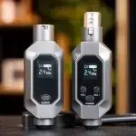 Two gray handheld wireless transmitters/receivers side by side, each with a small display showing 2.4 GHz and channel info, plus power and volume buttons. ขายราคาพิเศษ