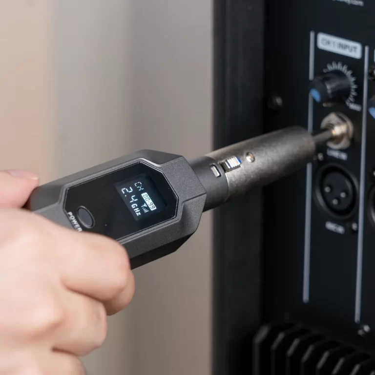 Person holding a digital infrared thermometer toward a control panel with knobs and a power indicator. ขายราคาพิเศษ