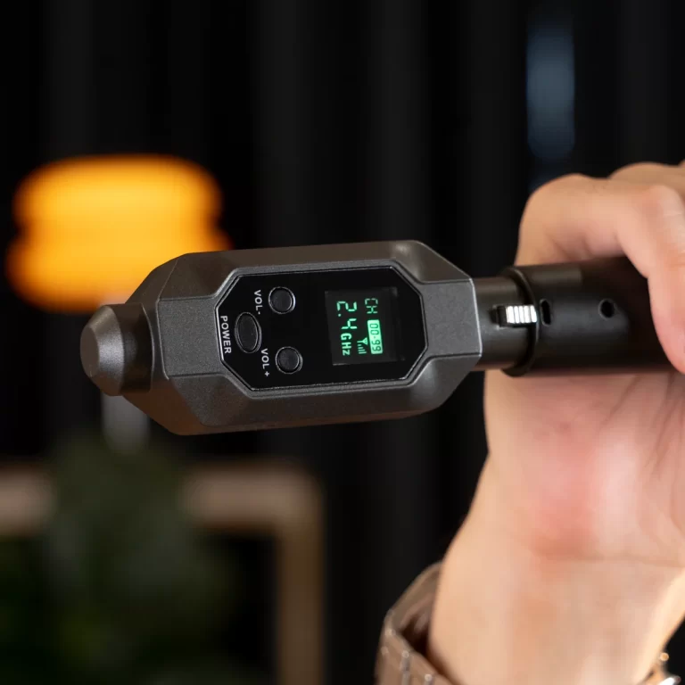 Close-up of a handheld electronic device with a green LCD screen and four control buttons, held by a right hand against a dark background. (informative) ขายราคาพิเศษ