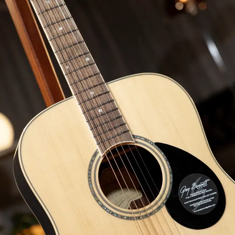 Close-up of an acoustic guitar neck and body showing the fretboard, strings, and soundhole with a natural wood finish. ขายราคาพิเศษ