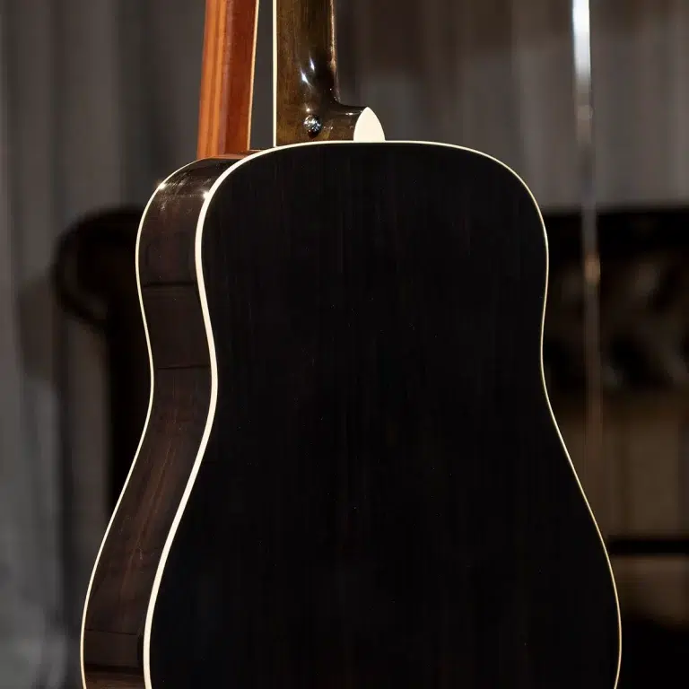 Back view of a black acoustic guitar with cream binding along the edges, seen from behind. ขายราคาพิเศษ