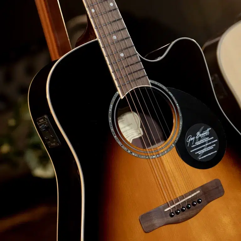 Close-up of a sunburst acoustic guitar showing the soundhole, rosette, and six strings on the fretboard area. ขายราคาพิเศษ
