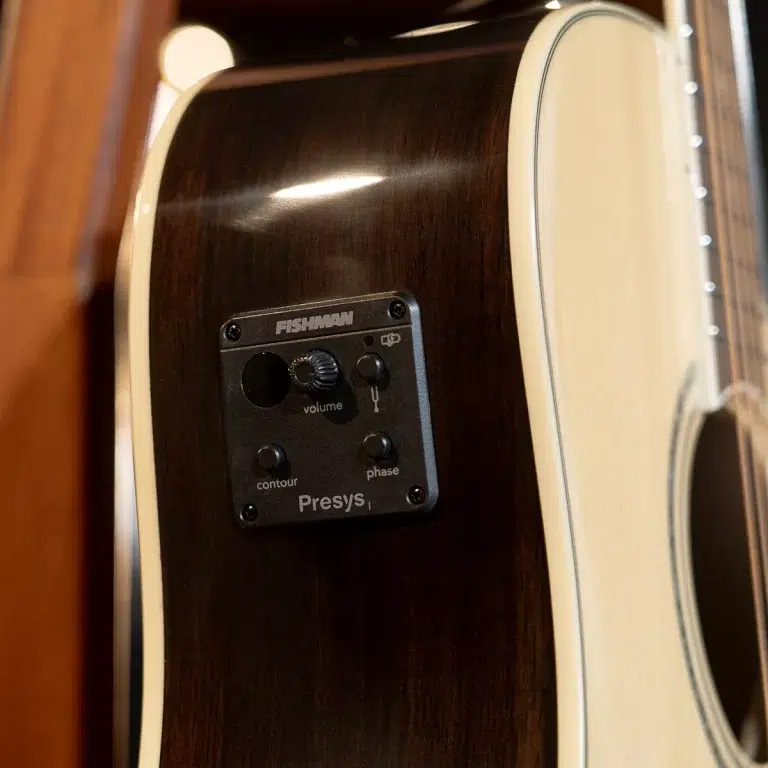 Close-up of a dark wood acoustic guitar with a Fishman Presys1 preamp panel on the side, showing volume, contour, and phase knobs. ขายราคาพิเศษ