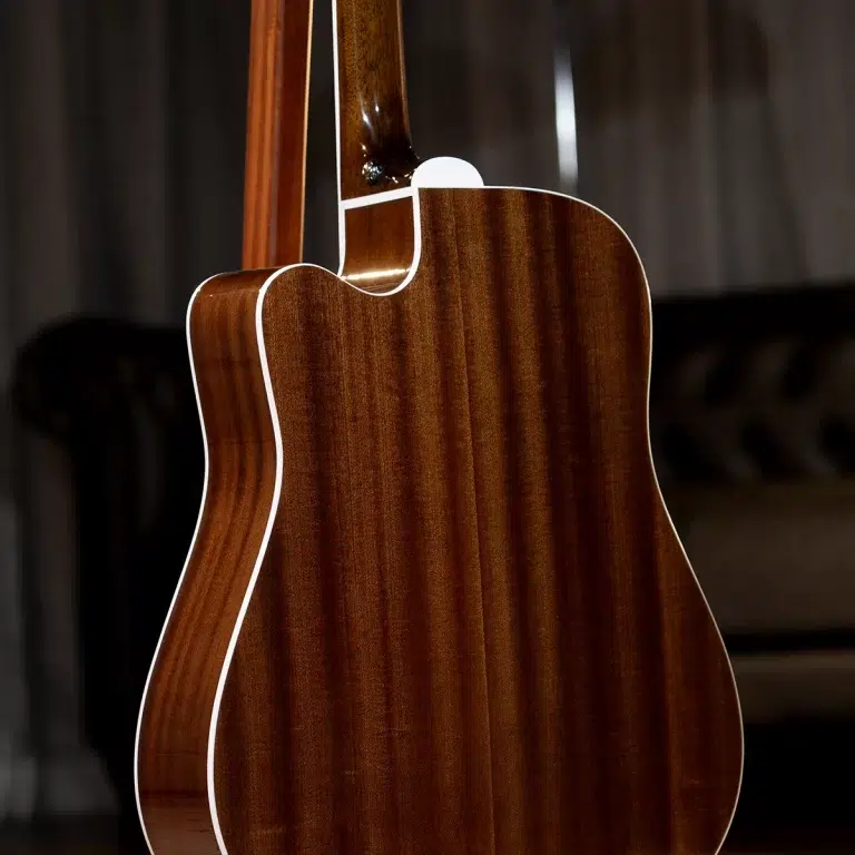 Close-up of a glossy brown acoustic guitar from the back, with white binding along the edges. ขายราคาพิเศษ