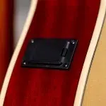 Close-up of the back of a red electric guitar, showing a black rectangular control/battery cover held by four screws with cream binding around the edge. ขายราคาพิเศษ