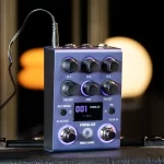 Compact guitar effects pedal with multiple knobs, small display, and purple-lit accents on a dark blue chassis. ลดราคาพิเศษ