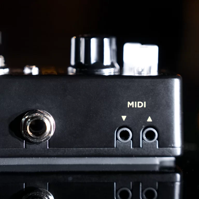 Close-up of a black MIDI interface panel with two small jack sockets and a larger input jack on the left. ขายราคาพิเศษ