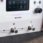 Close-up of a Mooer guitar effects pedal front panel showing two metal footswitches labeled B and C, with 'Hold for Tuner' and 'Hold for Looper' indicators nearby and a small display above. ขายราคาพิเศษ