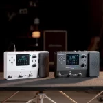 Two Mooer GE100 Pro multi-effects pedals on a table, white left and black right, each with a color display and built-in expression pedal area. ลดราคาพิเศษ
