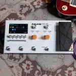 NUX MG-50 Li modeler guitar effects pedal on a patterned rug, with orange knobs and a foot pedal area visible ขายราคาพิเศษ