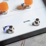 Close-up of a control panel with the word CTRL and two toggle switches with blue and purple caps on a white surface. ขายราคาพิเศษ
