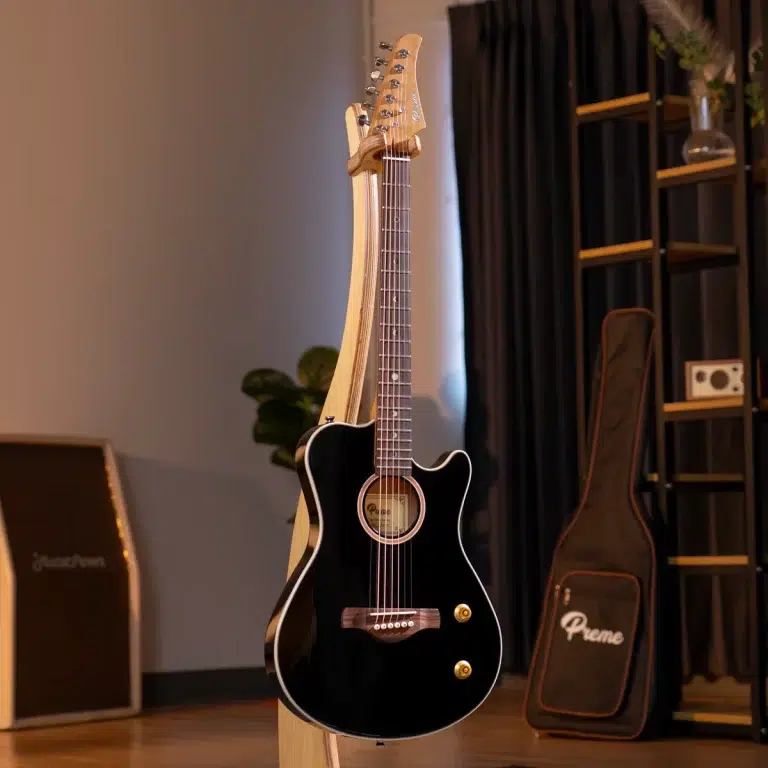 Black acoustic guitar on a stand in a cozy studio, with a wooden shelf and amplifier in the background ขายราคาพิเศษ