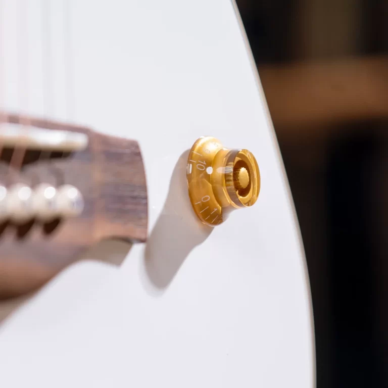 Close-up of a gold rotary knob on a white appliance panel with numbered markings visible. ขายราคาพิเศษ