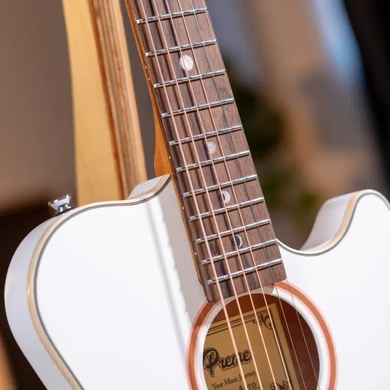 Close-up of a white acoustic guitar neck and fretboard with metal frets and pearl inlays near the soundhole. ขายราคาพิเศษ