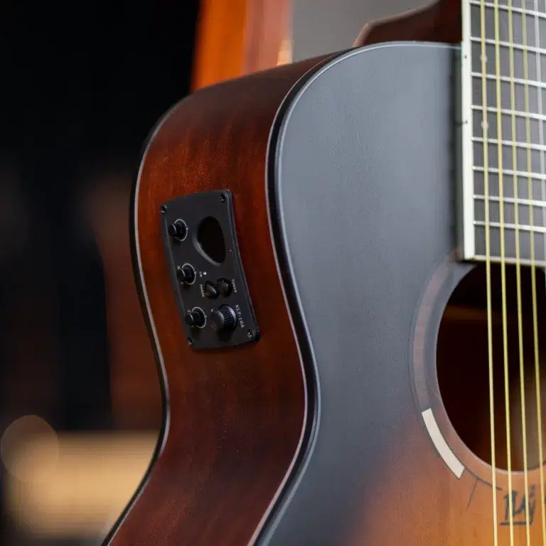 Close-up of an acoustic guitar body with a built-in electronics control panel on the side. ขายราคาพิเศษ