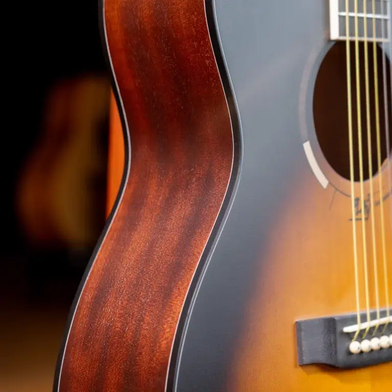 Close-up of an acoustic guitar showing a sunburst finish, wood grain, and strings near the soundhole ขายราคาพิเศษ