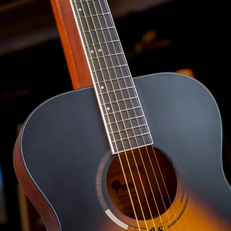 Close-up of a blue-gray acoustic guitar, showing the fretboard, six strings, and soundhole from the body side. ขายราคาพิเศษ