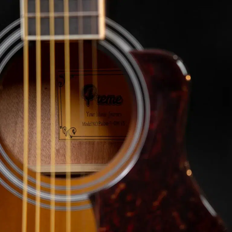 Close-up of an acoustic guitar showing the sound hole, rosette rings, and vertical strings with a label inside the body visible through the hole ขายราคาพิเศษ