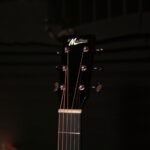 Close-up of a black guitar headstock with six tuning pegs and strings; brand name 'St Matthew' visible. ขายราคาพิเศษ